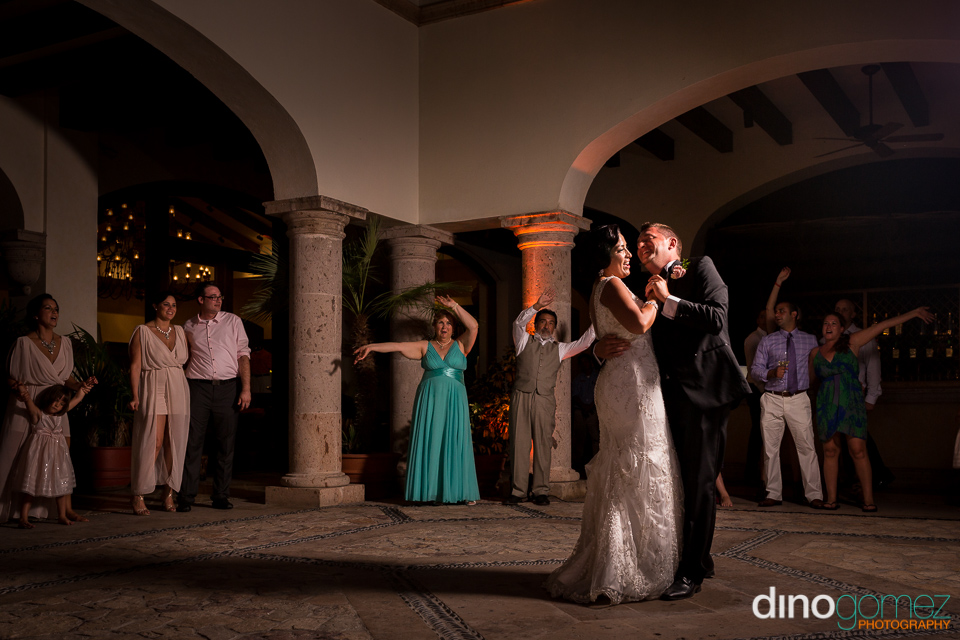 Cool Shot Of The Newlyweds Dancing And The Guests Waving In The Background