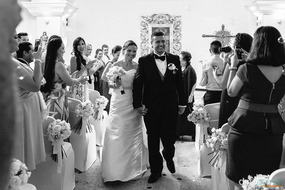 Beautiful Black And White Shot Of The Newlyweds Walking Don The Aisle As The Guests Cheer By Photographers In Puerto Vallarta