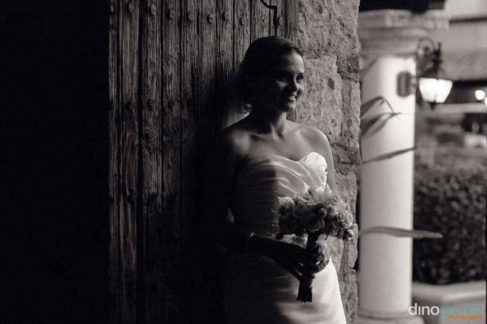 Elegant Black And White Bridal Portrait Of The Bride Holding Her Bouquet And Smiling By Wedding Photographer In Cabo Dino Gomez