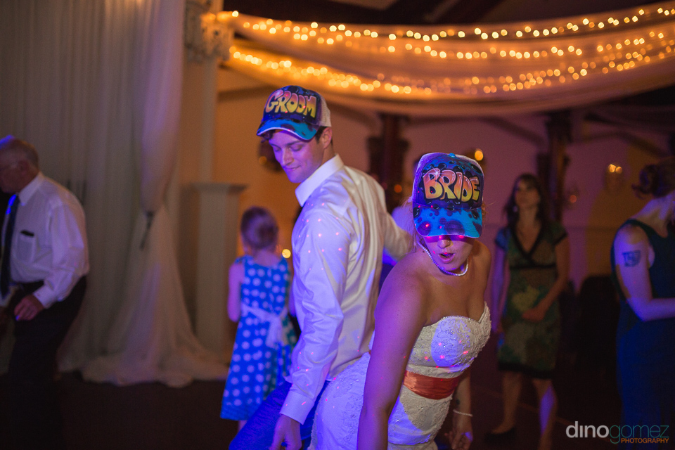 bride and groom funk dancing with matching caps