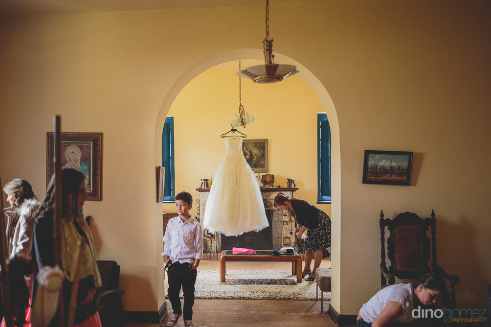 Wedding Dress Hangs While Guests Prepare the House