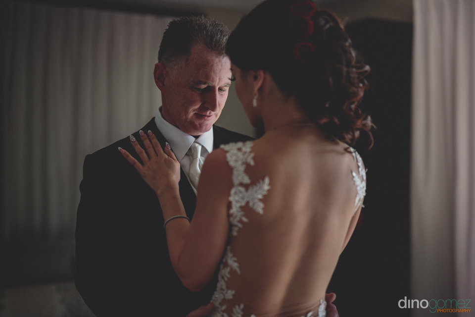 groom looks at bride with awe on their wedding day in cabo san l