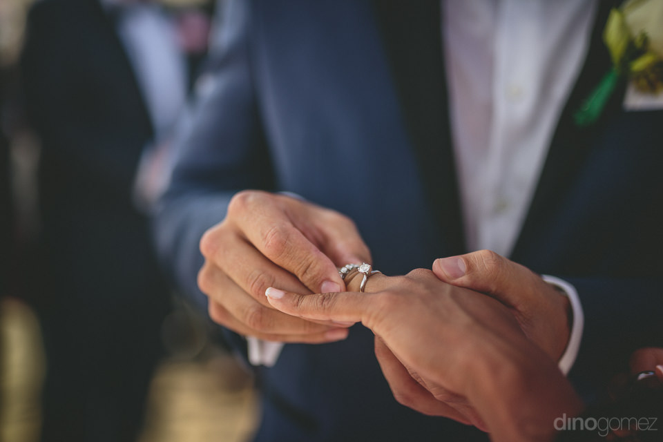 Groom Puts Rings On Brides Finger Diamond Wedding Rings Cabo Wed
