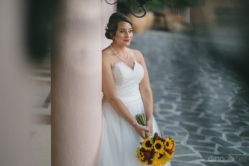 Bride leaning on a column - Jo & KC's Wedding in Cabo