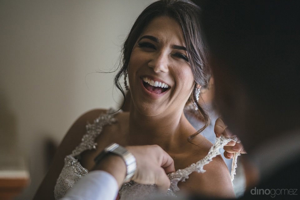 Smiling Bride Putting On Her Dress - Kimber & Julius' Wedding