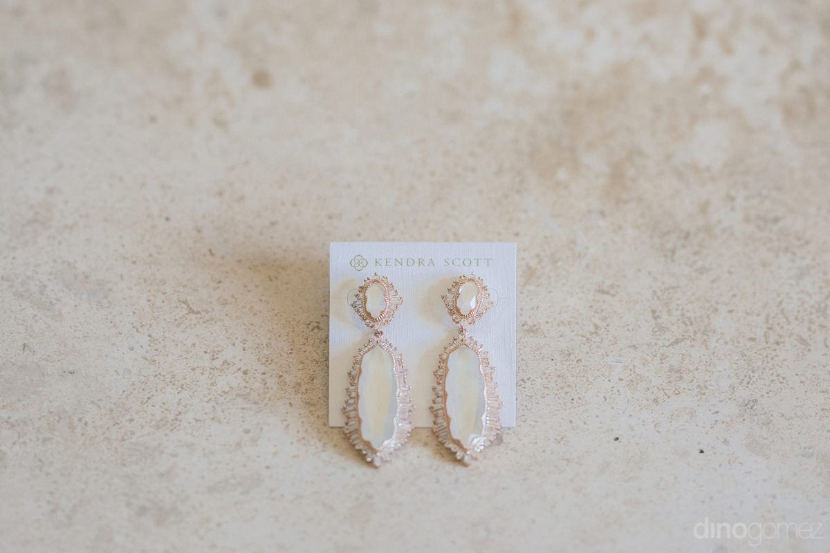 The Picture Captures A Beautiful Pair Of Crystal Earings Placed On A Light Colored Platform- Kathleen & Kevin