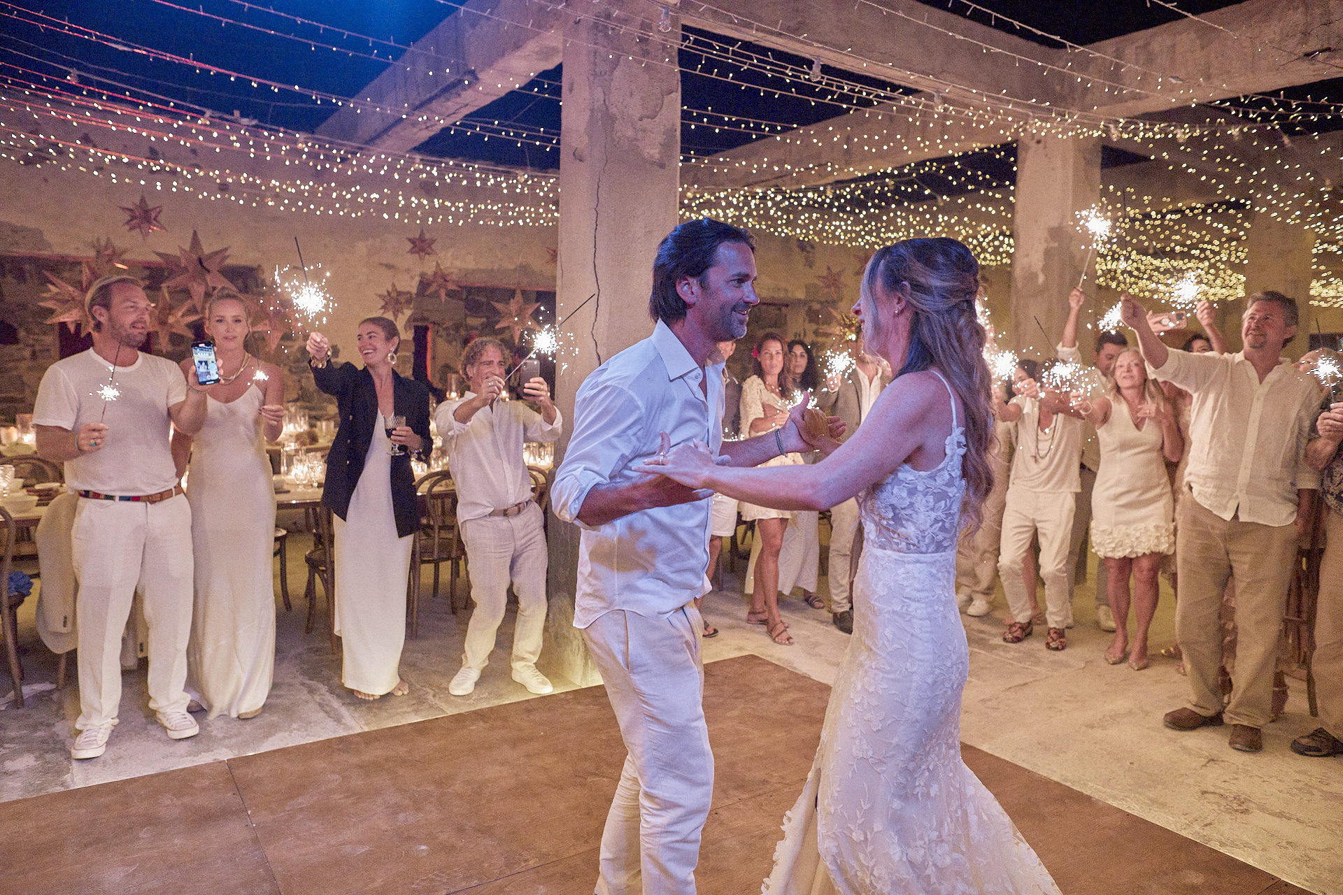 A Bride And Groom Dancing In Front Of A Crowd Of People.